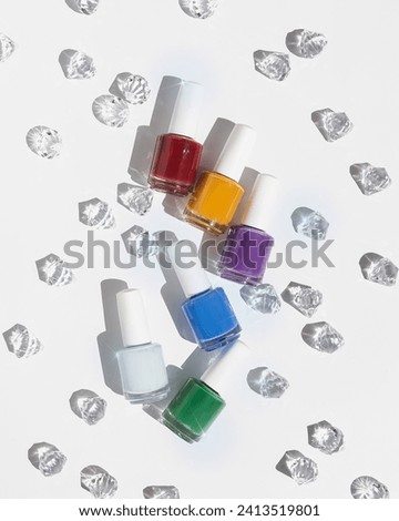 Set of colorful nail polish on white background with gems