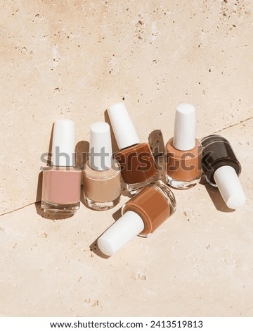 Set of beige nail polish on tan rock background 