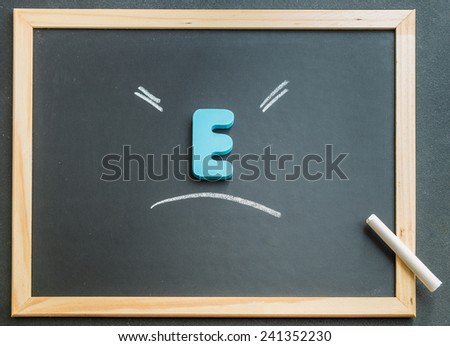 Wooden E character on black board