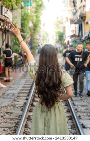 Tourists taking pictures of hurtling train. The Hanoi Train Street is a popular attraction.View of train passing through a narrow street of the Hanoi Old Quarter.
