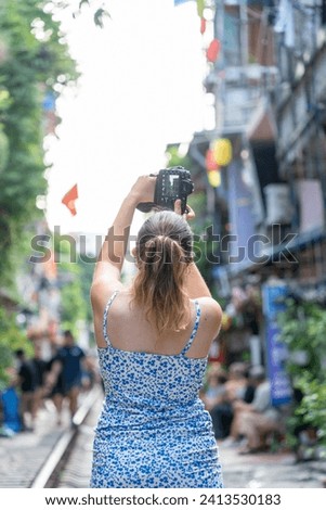 Tourists taking pictures of hurtling train. The Hanoi Train Street is a popular attraction.View of train passing through a narrow street of the Hanoi Old Quarter.