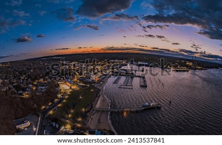 An aerial view of the Port Jefferson Harbor on Long Island, New York after a colorful sunset on a cloudy evening.