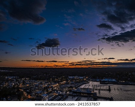 An aerial view of the Port Jefferson Harbor on Long Island, New York after a colorful sunset on a cloudy evening.