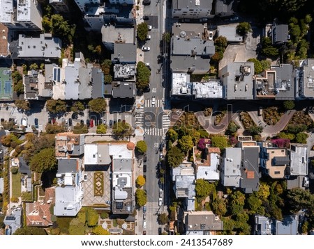 Panoramic view of aerial Lombard Street, an east–west street in San Francisco, California. Famous for steep, one-block section with eight hairpin turns. Tennis courts in San Francisco. Royalty-Free Stock Photo #2413547689