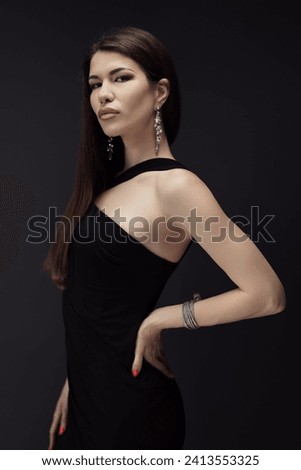 A woman looks elegant and stylish as she poses for a picture in her black dress.