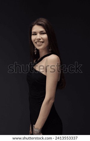 A woman elegantly poses in a classic black dress, ready to be captured in a memorable photograph.
