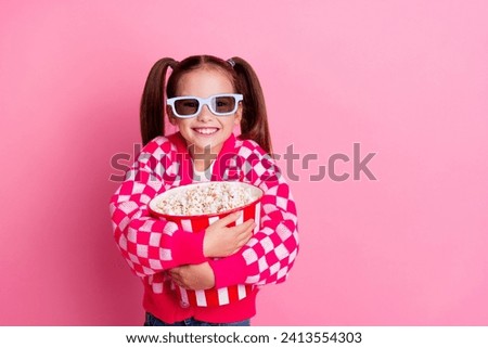 Photo of positive cute adorable girl wear trendy clothes hug basket popcorn cartoon movie empty space isolated on pink color background