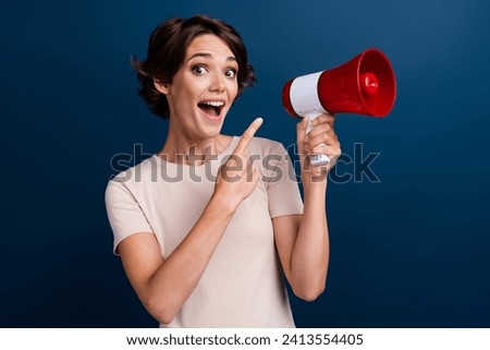 Photo portrait of pretty young girl point excited megaphone wear trendy white outfit isolated on dark blue color background