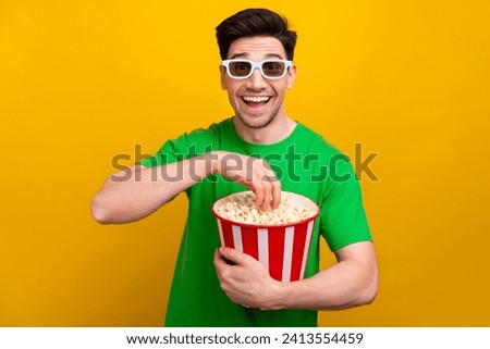 Photo of optimistic man with stylish haircut dressed t-shirt 3d glasses eating popcorn at cinema isolated on yellow color background