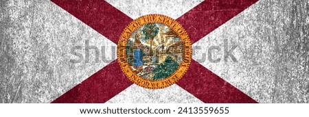 Close-up of the grunge Florida State flag. Dirty Florida State flag on a metal surface.