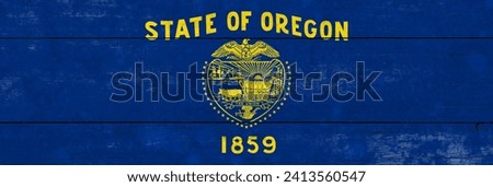 Oregon State flag on a wooden surface. Banner of the grunge Oregon State flag. 