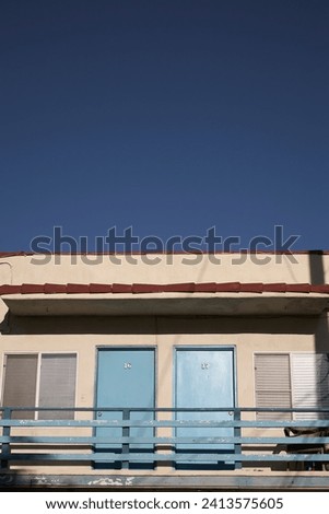 Facade of a motel in California showing room numbers 16 and 17, with blue doors.