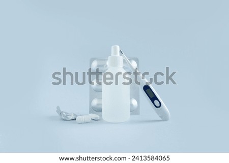 thermometer with white pills on a blue background. still life of medicines for health.