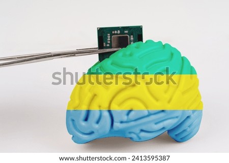 On a white background, a model of the brain with a picture of a flag - Gabon, a microcircuit, a processor, is implanted into it. Close-up