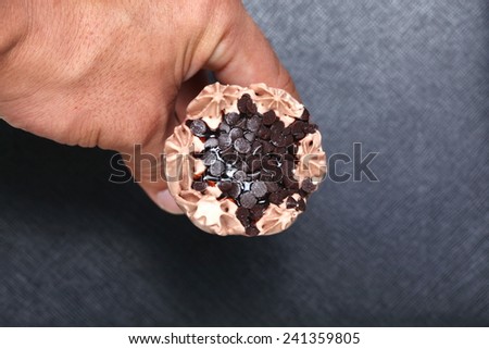 Ice cream in man hand photo caption on black color leather surface background represent the dessert related.
