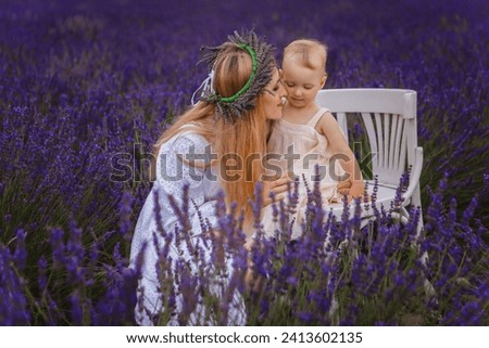 It is a picture of a small girl with her mother wearing a lavender wreath