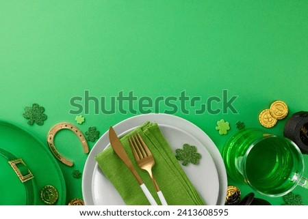 Embracing the spirit of St. Patrick's Day. Top view of plates, cutlery, napkin, leprechaun hat, pint of green beer, pots, coins, horseshoe, clovers on green background with advert space