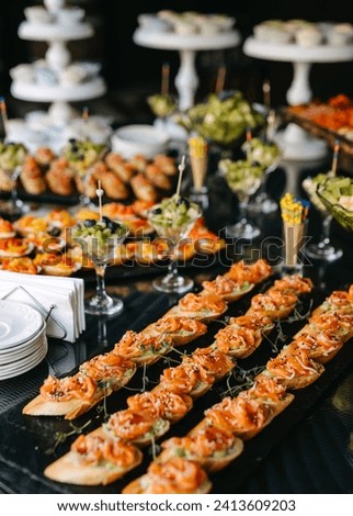 An array of gourmet appetizers displayed on a buffet, including salmon-topped crostini. Royalty-Free Stock Photo #2413609203