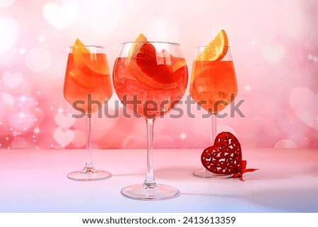 Festive alcoholic cocktail Aperol spritz in glasses and love hearts, bar concept and valentine's day, alcoholic drinks at party, restaurant advertising, selective focus Royalty-Free Stock Photo #2413613359
