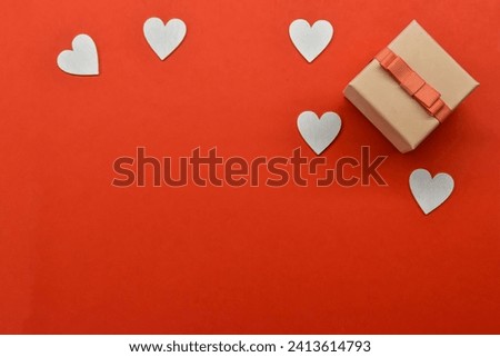  Graceful Composition Showcasing a Pink Gift Package Embellished with an Abundance of White Hearts on a Vibrant Red Background - SEO-Optimized