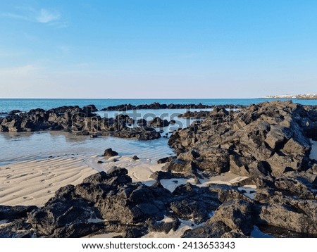 This is a Jeju seascape with basalt rocks. Royalty-Free Stock Photo #2413653343