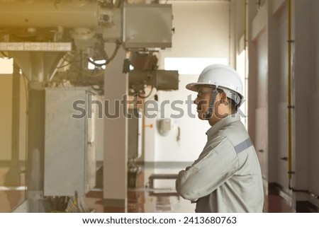 Engineers technicians man wearing professional helmets working in powerhouse or power plant. Royalty-Free Stock Photo #2413680763
