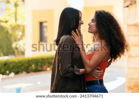 interracial lesbian couple kissing outdoors