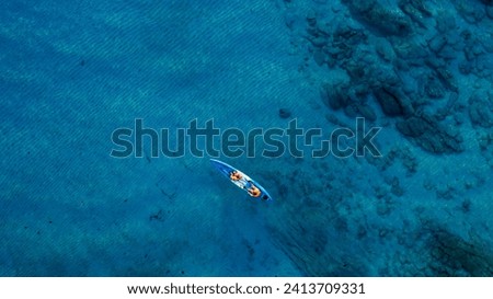 Aerial view of a kayak in the blue sea .Woman kayaking She does water sports activities. Royalty-Free Stock Photo #2413709331
