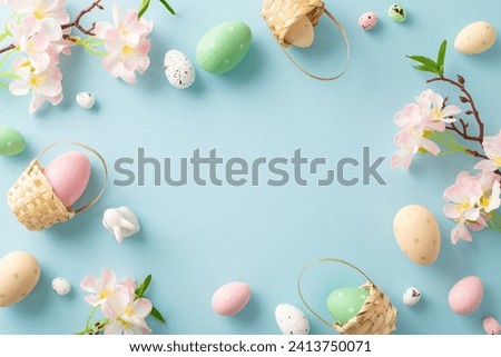 Cheerful Easter top view display: tiny baskets cradling colorful eggs, an adorable bunny, apple blossoms on a soft pastel blue surface. Perfect for your festive messages or promotional content
