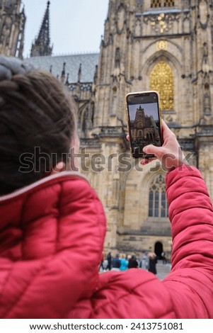 Tourist girl traveling St. Vitus Cathedral takes a photo in Prague social media