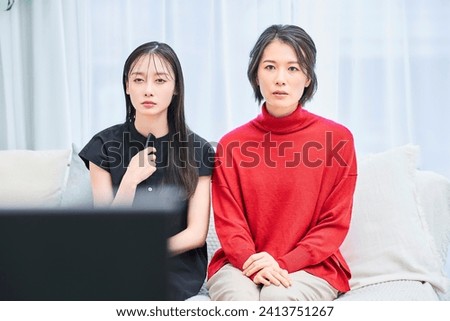 two women watching tv in the room