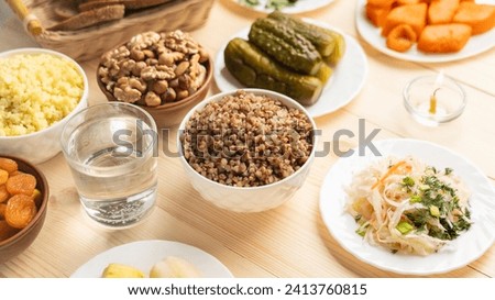 boiled buckwheat porridge, nuts, boiled potatoes, bread, sauerkraut, on wooden background, food without animal fats, pickled cucumbers,