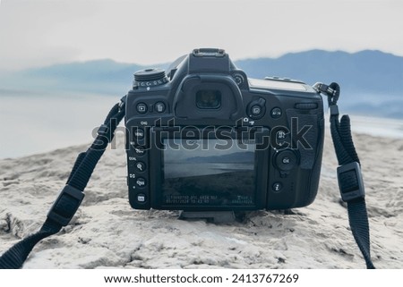The camera shoots a mountain landscape in live view mode. Selective focus.Old damaged traveler's camera.