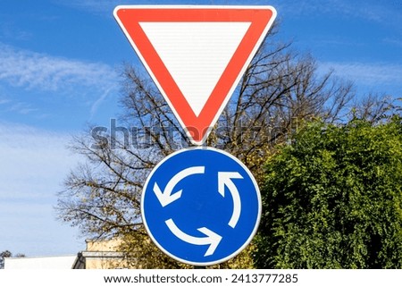 Traffic sign for yielding the right of way and a sign for a roundabout.