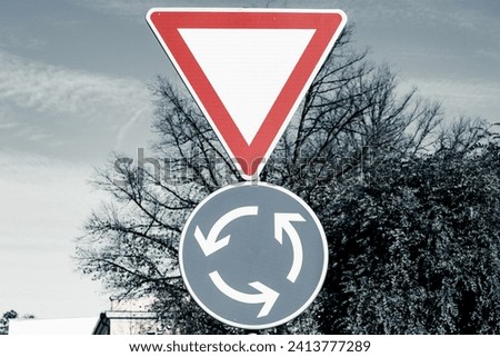 Traffic sign for yielding the right of way and a sign for a roundabout.
