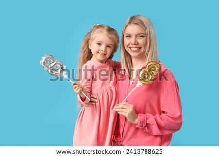 Little girl and her mother with figures 8 on blue background. International Women's Day celebration