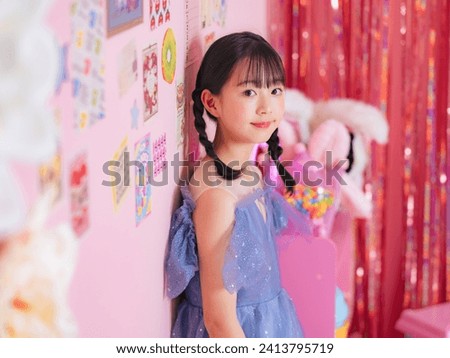 Portrait of Asian little girl wearing party dress in girly pink room. Photo studio. Memorial photo.