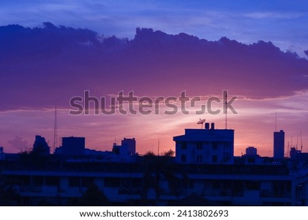 The colors of the last rays of the sky are beautiful with clouds and the tops of buildings with antennas and satellite dishes, a high-angle view of Bangkok on the western side.