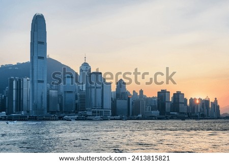 Awesome view of Victoria Harbor and skyscrapers in downtown of Hong Kong at sunset. Amazing cityscape. Hong Kong Island skyline. Hong Kong is a popular tourist destination of Asia.