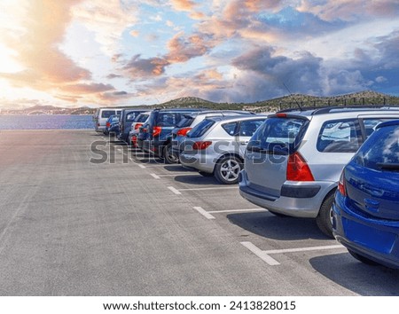Car parking. Cars are parked in a paved parking lot near a pond. Royalty-Free Stock Photo #2413828015