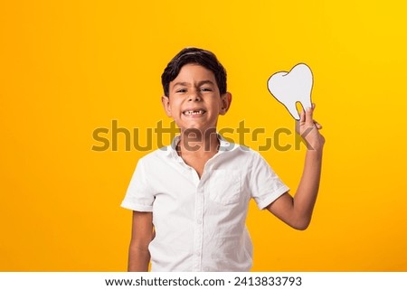 Boy holding papercraft tooth.  Dental health concept