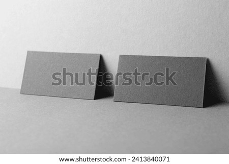 Blank black business cards on grey background. Mockup for design