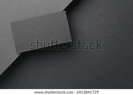 Blank business card on black background, top view. Mockup for design