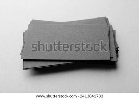 Blank black business cards on light background, closeup. Mockup for design