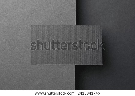 Blank business card on black background, top view. Mockup for design