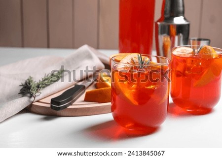 Aperol spritz cocktail, rosemary and orange slices on white wooden table Royalty-Free Stock Photo #2413845067