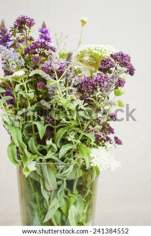 a vase of wildflowers on white wooden table