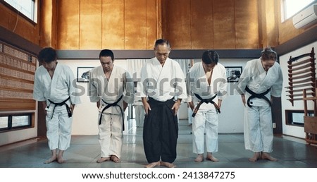Martial arts group, men and bow at training, respect or honor for fight, conflict or competition in dojo. Senior sensei, Japanese students and together for aikido with exercise, workout or discipline Royalty-Free Stock Photo #2413847275