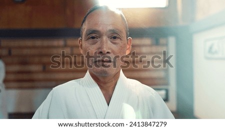 Sensei, aikido and training dojo for martial arts practice or Japanese traditional sport, fighting or health. Male person, gee uniform and face for fitness challenge or power, champion or confidence Royalty-Free Stock Photo #2413847279