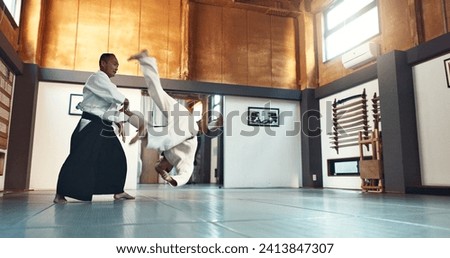 Aikido, fight and sensei master in martial arts with training of student in self defence or discipline. Class, demonstration and Japanese man with black belt in fighting for education of skill Royalty-Free Stock Photo #2413847307